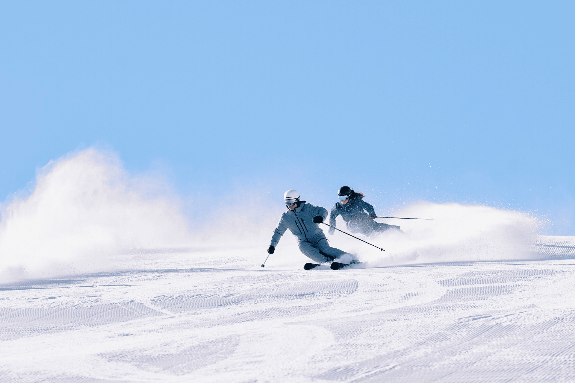 Schneebedeckte Berge unter einem klaren Himmel, mit Bäumen und einer kleinen Hütte im Vordergrund. Die ruhige, unberührte Landschaft strahlt Gelassenheit aus.