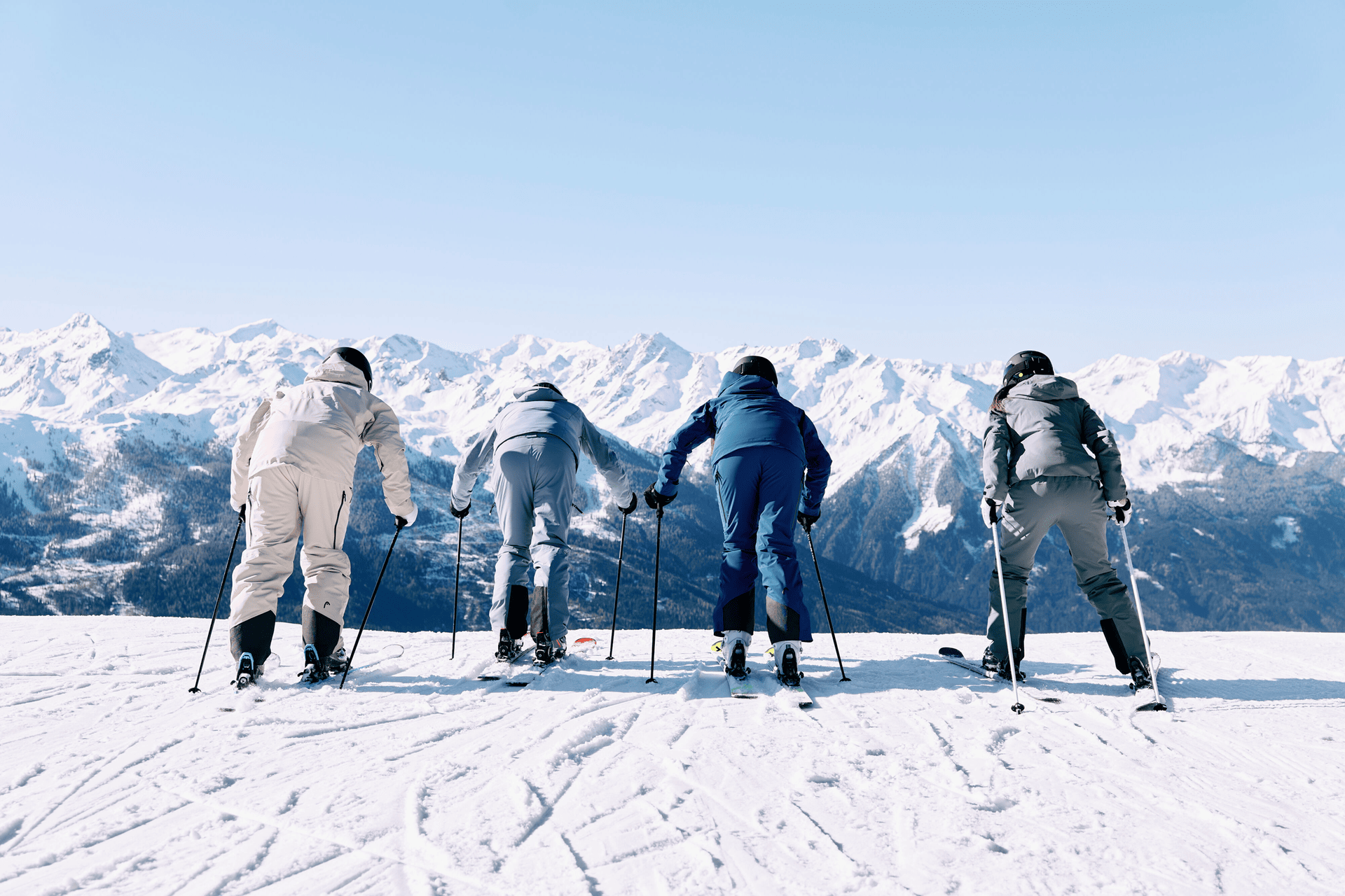 Ein Skifahrer fährt links einen verschneiten Hang hinunter, während Wanderer in bunten Jacken rechts den Berg erklimmen. Der bewölkte Himmel sorgt für eine dramatische, abenteuerliche Kulisse.